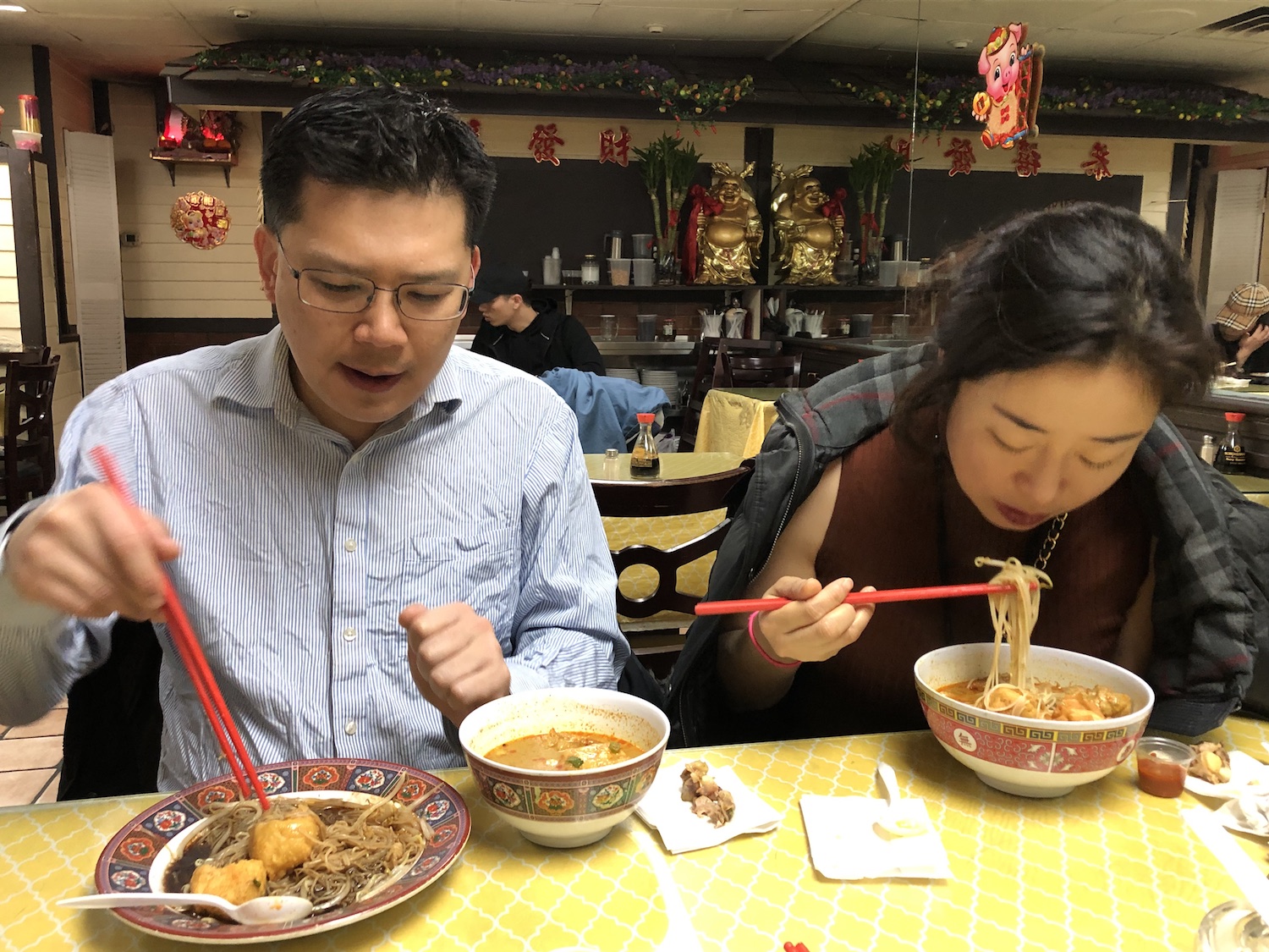 Taehoon and Lea Kim enjoying bowls of curry laksa, Malaysian breakfast noodle soup, at Curry Leaves.