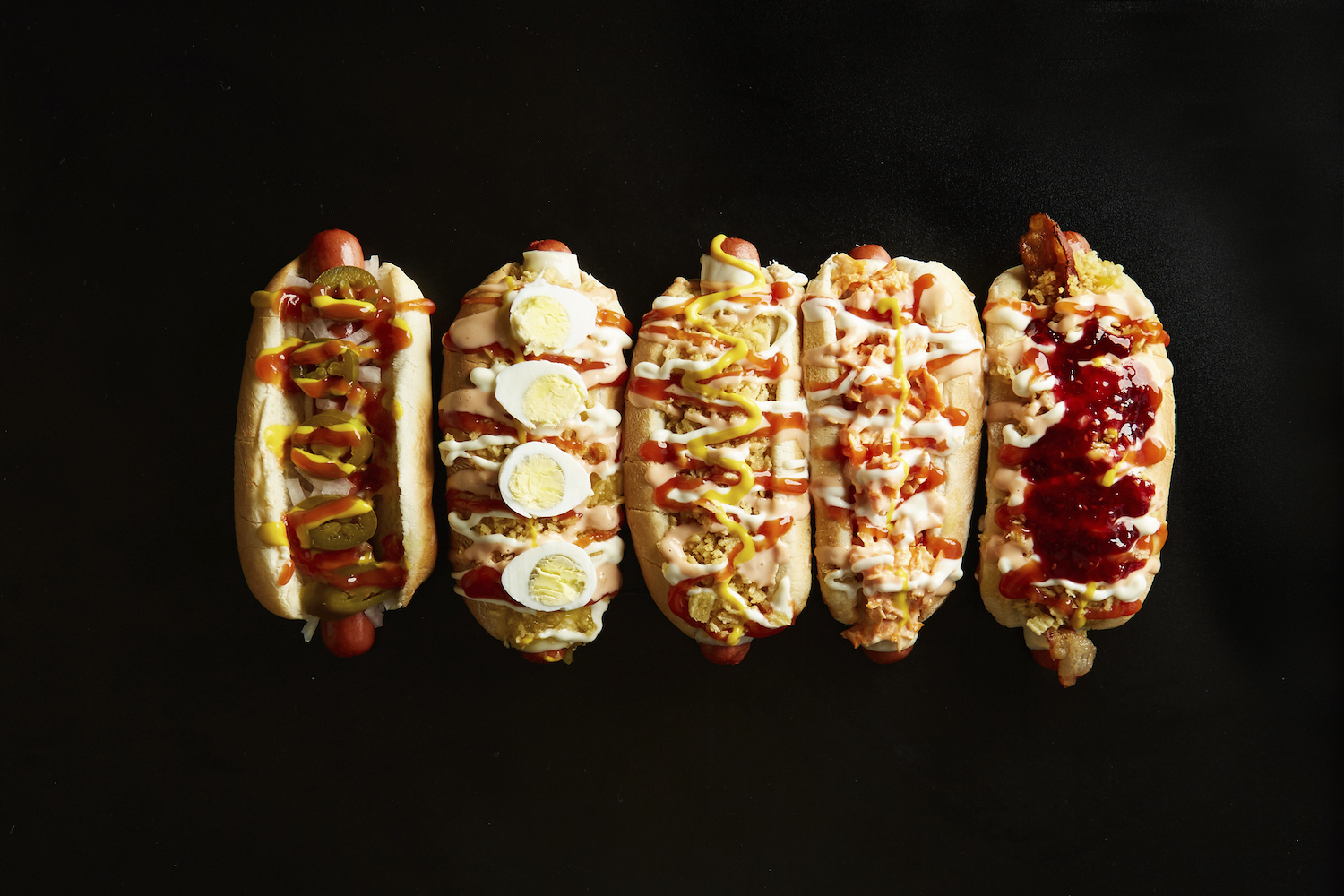 The lineup of specialty hot dogs from El Perro in Jackson Heights.
