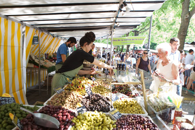 An olive vendor at the Marche' Bastille Market