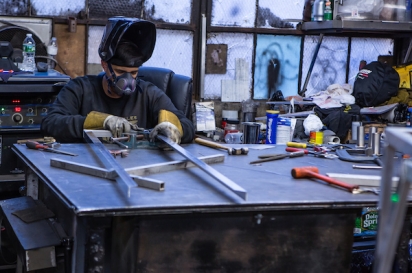 Welder Joshua Sanchez of 800BuyCart working on an aluminum frame for a food cart canopy.