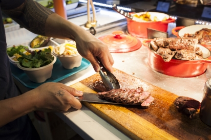 Beef tenderloin being sliced behind the counter at Ok Lah! in Flushing, Queens.