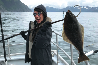 Melissa Kravitz proudly poses for a picture with the halibut she caught fishing in Alaska.