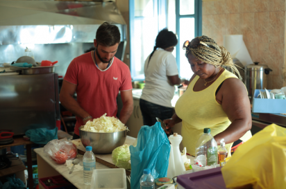 Immigrant chefs cooking in the kitchen of Welcome Home in Lesbos, Greece.