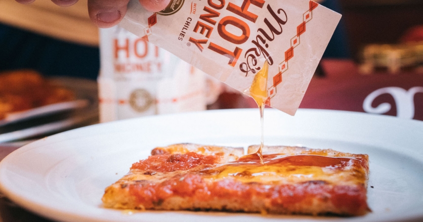 Pictured here is the new sauce packet version being drizzled over a King Umberto’s celebrated invention, the “Grandma Pizza”.