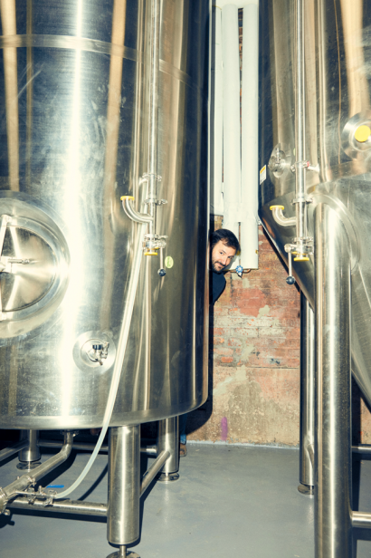 Owner, Chris Cuzme, hiding out behind one of Fifth Hammer Brewery's beer tanks.