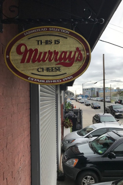 An oval sign above the glass door hints at the treasures to be found within the cheese caves at Murrays Cheese Distribution Center on Borden Avenue, Long Island City.