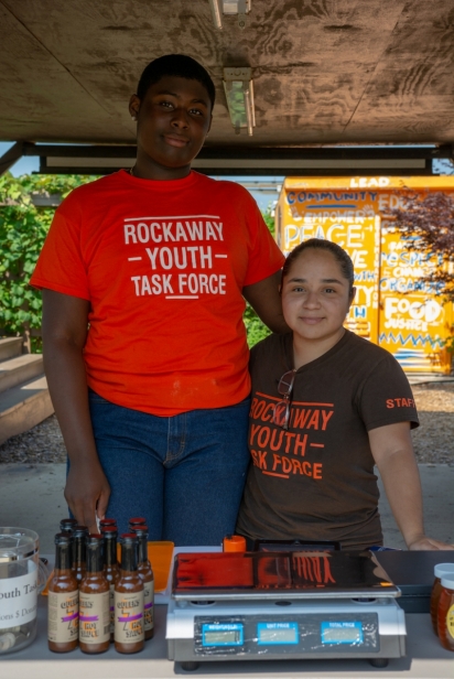 Noah Roberts and Andrea Colon ready the farm stand for their first day of the season. The hot sauce for sale is made with jalapeños grown on the farm.