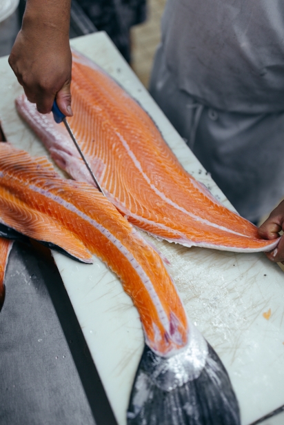 Skilled hands and a sharp knife fillet salmon at Crossbay Seashell Fish Market in Queens.