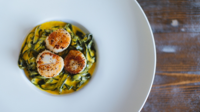 Htenia is a dish of grilled scallops with squid ink linquini and a saffron emulsion at Akrotiri in Astoria.